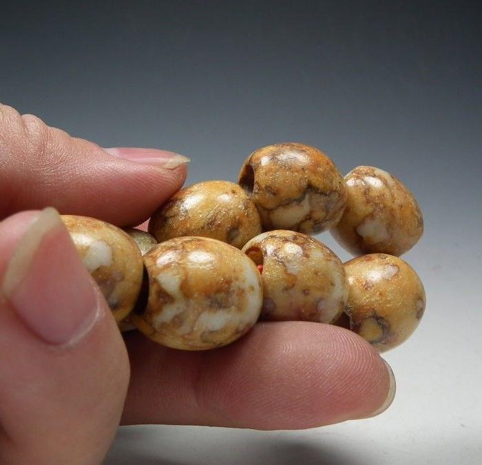 描述:描述:良渚文化矾石红种带沁通天孔大勒子手串